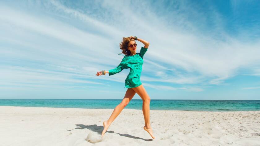 Perfect tan slim sexy woman runs along the beach